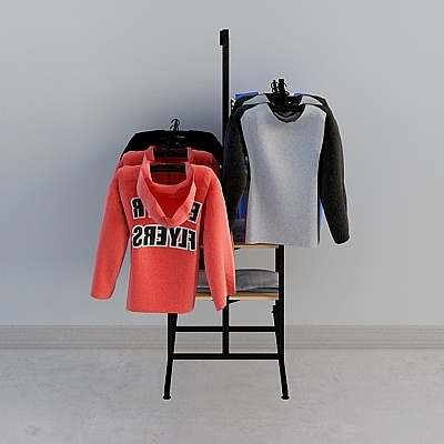 Black metal clothing rack holding colorful sweaters and shirts on white background