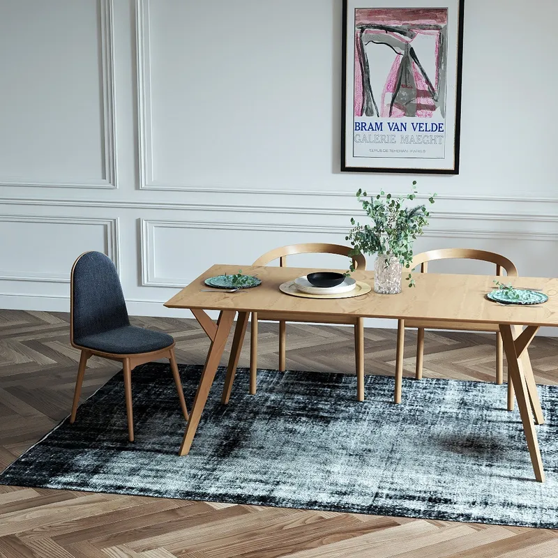 Wooden dining table with grey chair and wooden chairs on rug with white wall panels