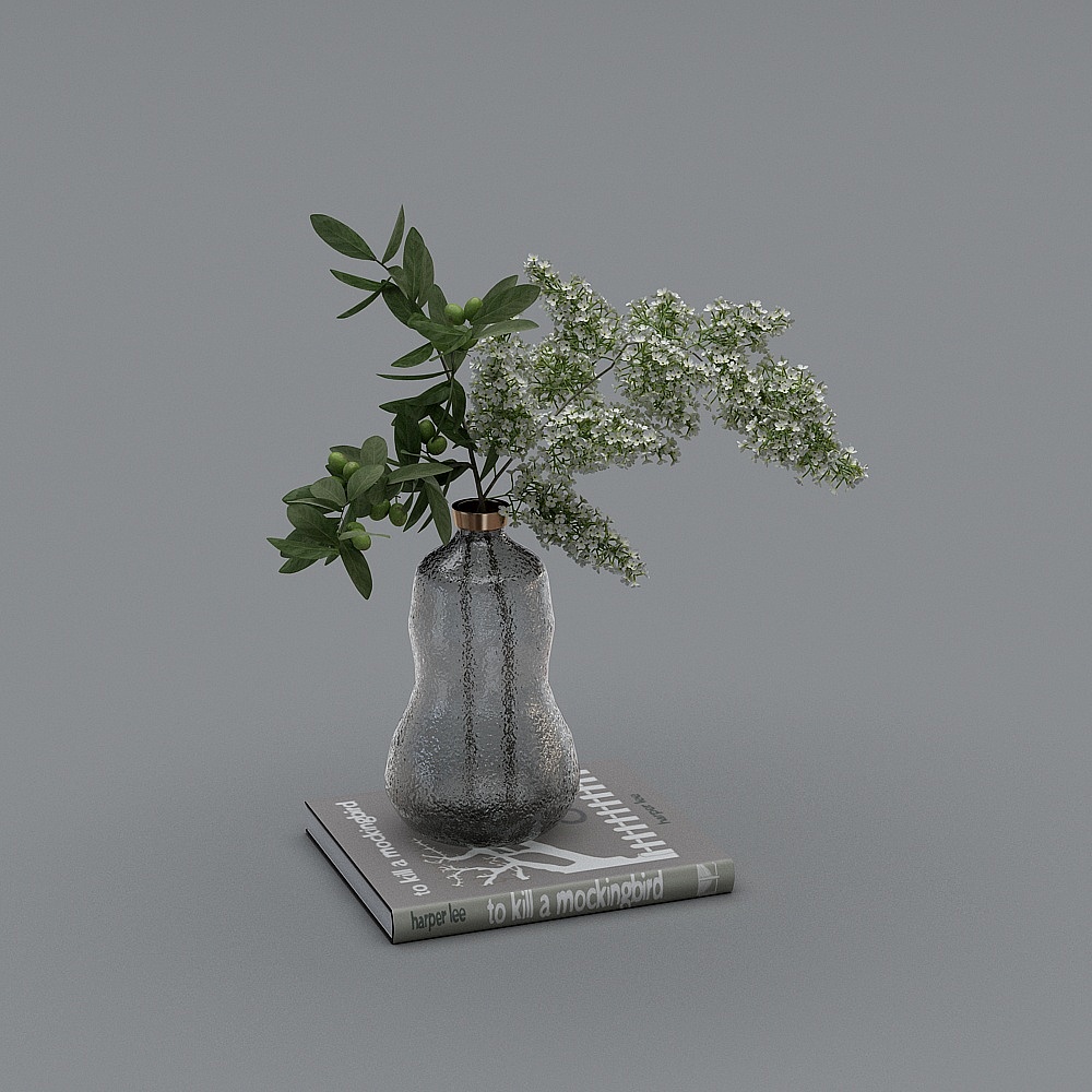 Textured grey glass vase with green leaves and white flowers on book on grey background