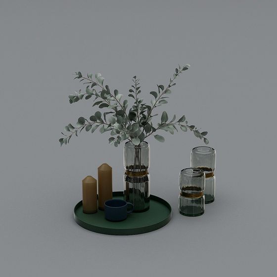 Modern glass vases with green leaves on tray with candles and cup on grey background